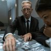 pexels-photo-6069237-6069237 Two detectives focus on evidence in a dimly lit room, analyzing photographs and documents.